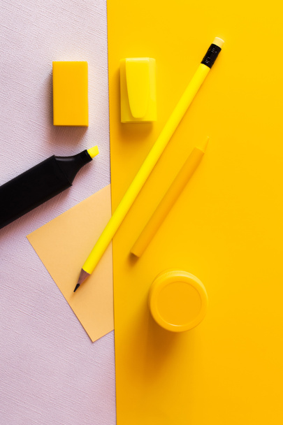 вид зверху канцелярського приладдя і маркерна ручка біля паперової ноти на жовтому і білому
  - Фото, зображення