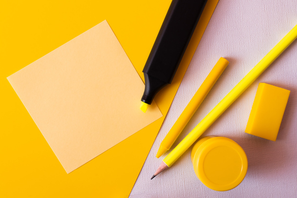 κορυφαία άποψη της γραφικής ύλης και μαρκαδόρου στυλό κοντά σε χαρτί σημείωμα σε υφή λευκό και κίτρινο - Φωτογραφία, εικόνα