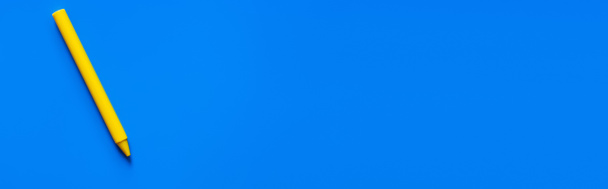 top view of yellow crayon on blue background, banner - Photo, Image