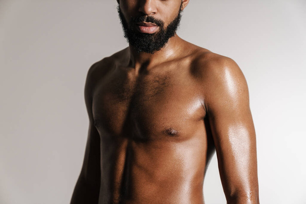 Black shirtless bearded man posing on camera isolated over white background - Foto, afbeelding