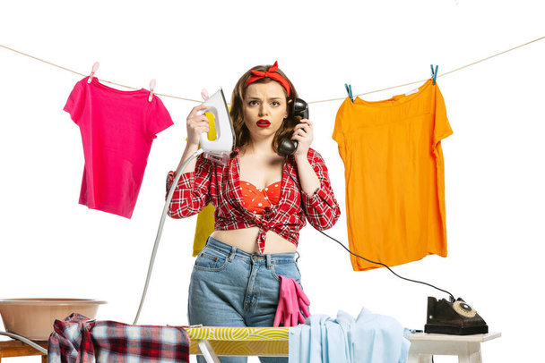 Laundry, cleaning, ironing. Beautiful housewife doing housework isolated on white studio background. Work, emotions, female rights, beauty, family - Photo, Image