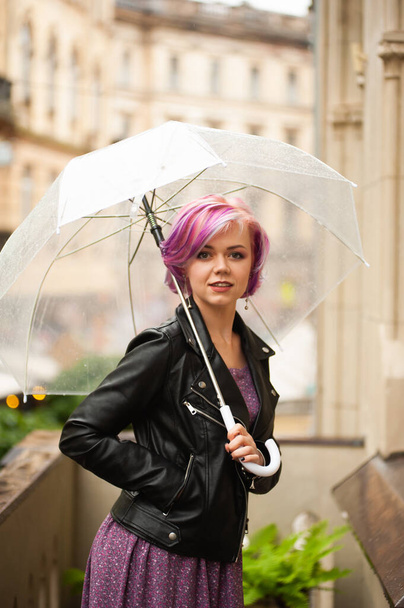 Βροχερή μέρα. Χαμογελαστή γυναίκα με καθαρή ομπρέλα - Φωτογραφία, εικόνα