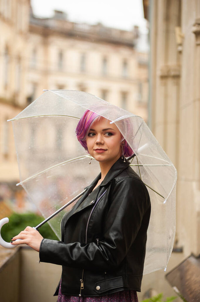 Βροχερή μέρα. Χαμογελαστή γυναίκα με καθαρή ομπρέλα - Φωτογραφία, εικόνα