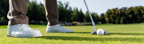 cropped view of man in white sneakers playing golf on lawn, banner - Foto, Imagem