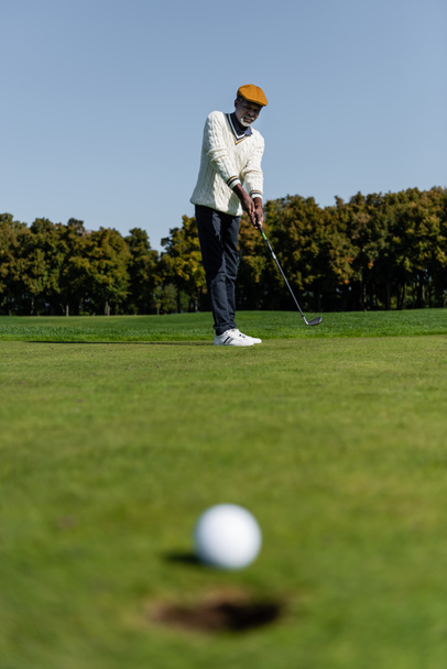 hombre afroamericano jugando al golf en el campo verde  - Foto, imagen