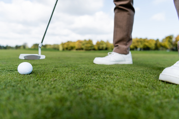 cropped view of blurred man playing golf on lawn - Zdjęcie, obraz
