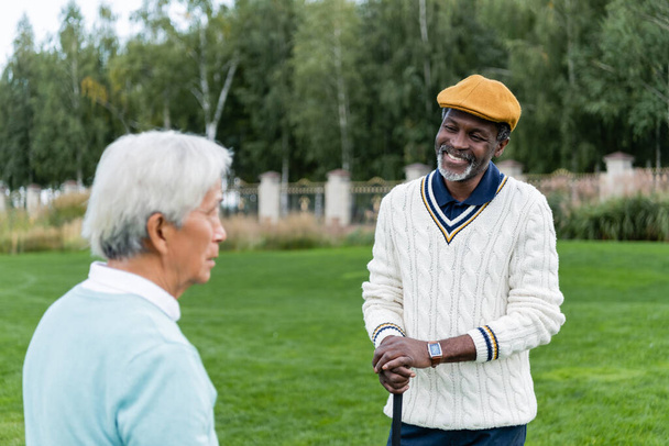 sonriente africano americano hombre mirando senior asiático amigo  - Foto, Imagen
