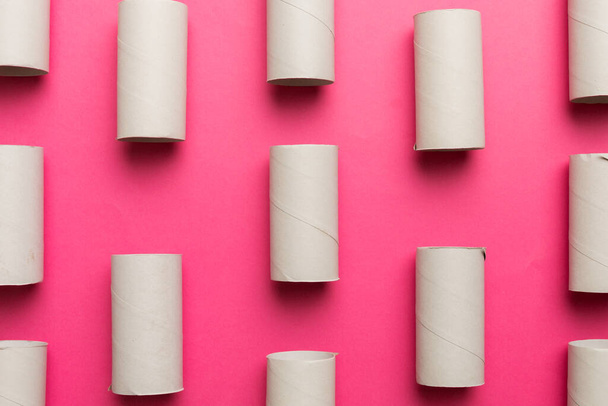 Leere Toilettenpapierrolle auf farbigem Hintergrund. Recyclingpapierröhre mit Metallstecker aus Kraftpapier oder Karton. - Foto, Bild