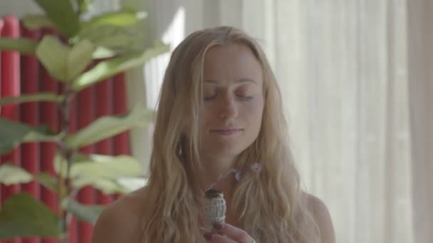 Mooie blonde blanke jonge vrouw maakt meditatie met salie vlekken stokken. Videomateriaal nog steeds opgenomen portret. - Video