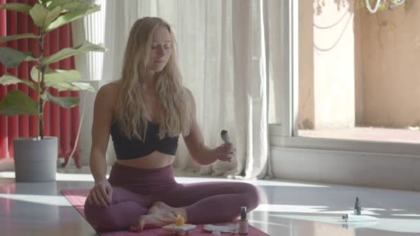 Krásná blond běloška mladá žena dělá meditaci šalvějí šmouhou šmouhy hole. Video záběry stále pořízeny portrét. - Záběry, video