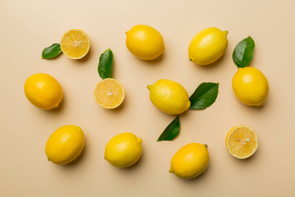 Sok friss érett citrom, mint színes háttér, felülnézet. Elegáns háttér citrom és citrom szeletek Top view flat lay. - Fotó, kép