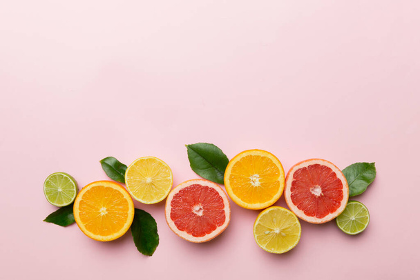 Фруктовый фон. Цветные свежие фрукты на цветном столе. Оранжевый, лимонный, грейпфрутовый Пространство для текста здоровой концепции. Плоская кладка, вид сверху, копировальное пространство. - Фото, изображение