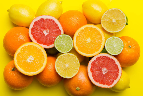 Flache Lage von Zitrusfrüchten wie Limette, Orange und Zitrone mit Zitronenblättern auf hellem Hintergrund. Raum für ein textgesundes Konzept. Ansicht von oben. - Foto, Bild