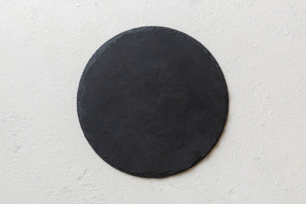 top view of empty black slate plate on cement background. Empty space for your design. - Photo, Image