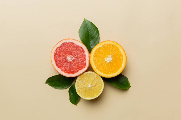 Owocowe tło. Kolorowe świeże owoce na kolorowym stole. Pomarańczowy, cytrynowy, grejpfrutowy Przestrzeń dla tekstu zdrowej koncepcji. Płaskie ułożenie, widok z góry, przestrzeń do kopiowania. - Zdjęcie, obraz