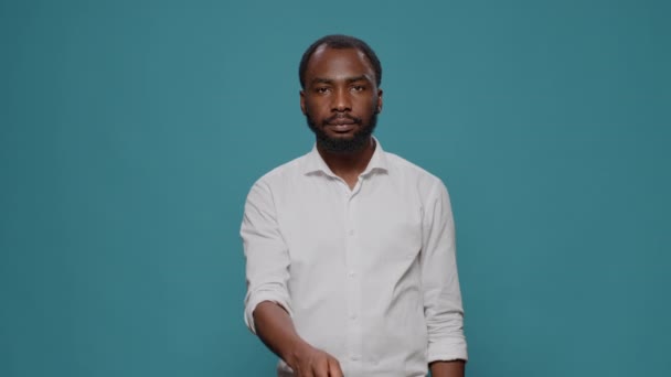 Ritratto di modello maschile che mostra il segno del silenzio davanti alla telecamera - Filmati, video