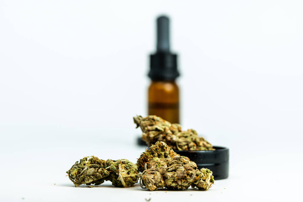 Detailní záběr lékařských marihuanových pupenů a konopného oleje na bílém pozadí. Koncept bylinné a alternativní medicíny - Fotografie, Obrázek