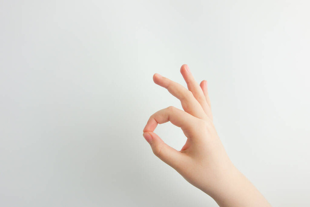 Child's hand is making OK gesture. Success, agreement, approval concepts. White background with copy space for your design - Foto, Bild