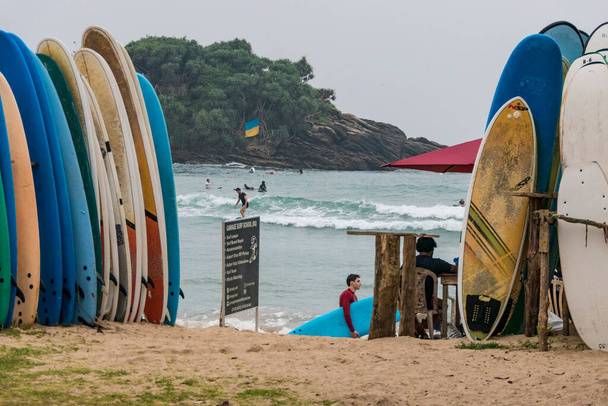 Hiriketiya Beach, Sri Lanka Tourists surfing under a Ukrainian flag. - Fotografie, Obrázek