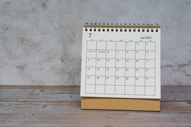 White July 2022 calendar on wooden desk. 2022 new year concept. Copy space. - Фото, изображение