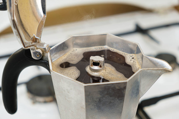 Gorąca świeżo parzona kawa w ekspresie do kawy gejzera stojąca na gazowym piecu - Zdjęcie, obraz