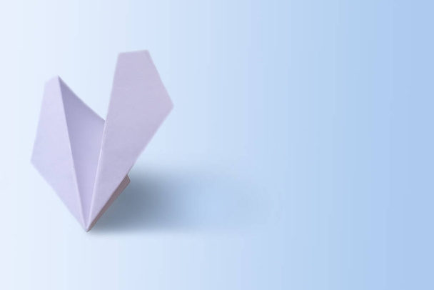 Avión de papel sobre fondo de papel azul
 - Foto, Imagen