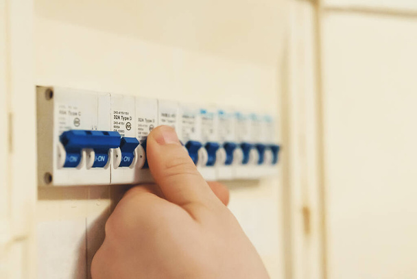 Male hand switching on fuse board. - Photo, Image