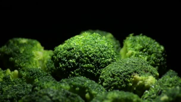 Brokoli, siyah arkaplan ve yakın ışık ile dönüyor. - Video, Çekim