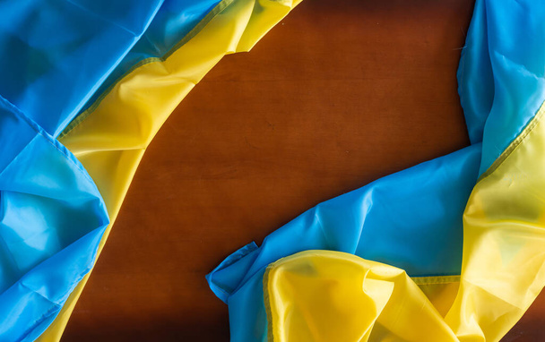 Oekraïense vlag op houten tafel achtergrond - Foto, afbeelding