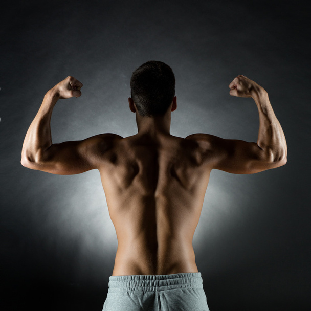 young man showing biceps - Foto, Bild