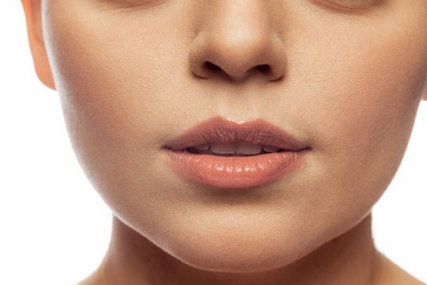 Cropped close-up image of female lips, cheecks and nose isolated over white studio bacground - Фото, изображение
