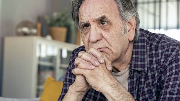 Thoughtful elderly man sitting alone at home - Fotografie, Obrázek