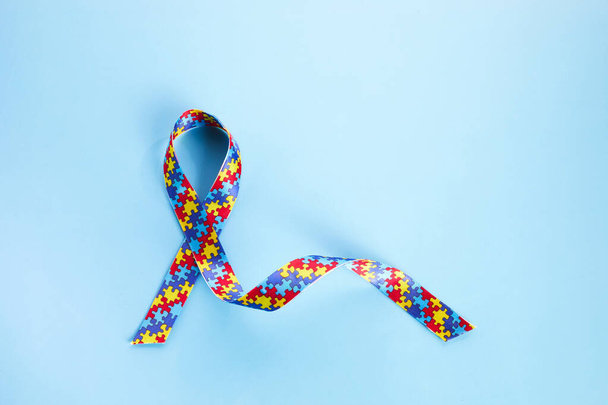Autism awareness concept with colorful ribbon on blue background. Top view - Foto, immagini