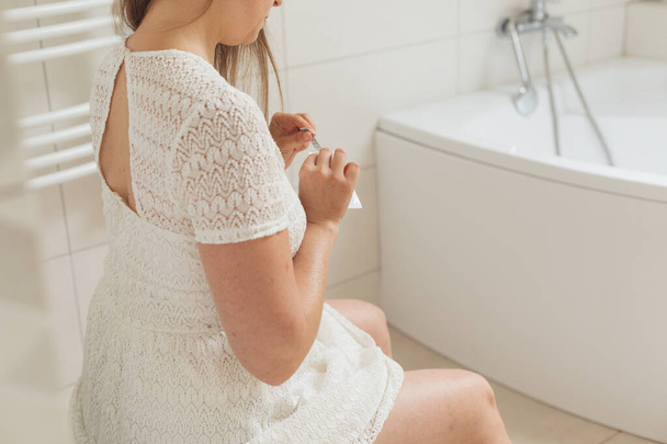 Mujer de mediana edad con prueba de embarazo en el baño - Foto, imagen