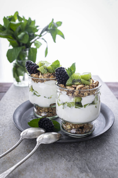 Parfait with kiwi, blackberries, granola and yogurt. Healthy and delicious dessert - Valokuva, kuva