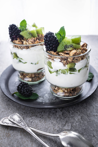 Parfait with kiwi, blackberries, granola and yogurt. Healthy and delicious dessert - Foto, Bild