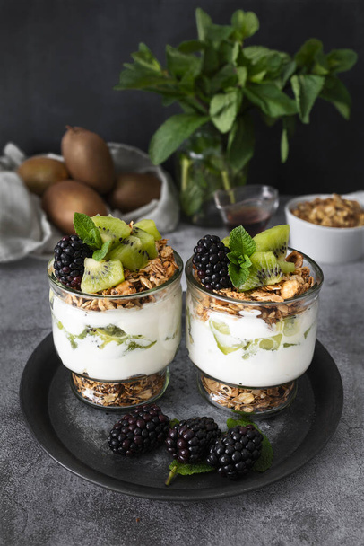 Parfait with kiwi, blackberries, granola and yogurt. Healthy and delicious dessert - Zdjęcie, obraz