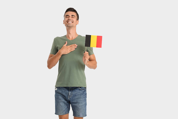 Młody człowiek z flagą Belgii na tle światła - Zdjęcie, obraz