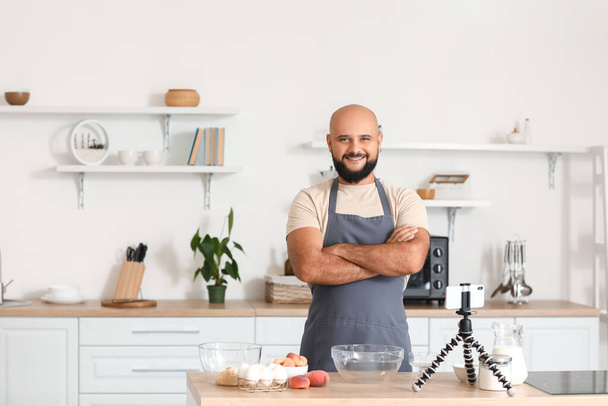Schöner Mann kocht mit Videotutorial in der Küche - Foto, Bild