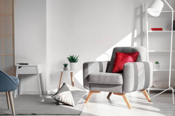 Интерьер светлой гостиной с мягким креслом и белой лампой - Фото, изображение