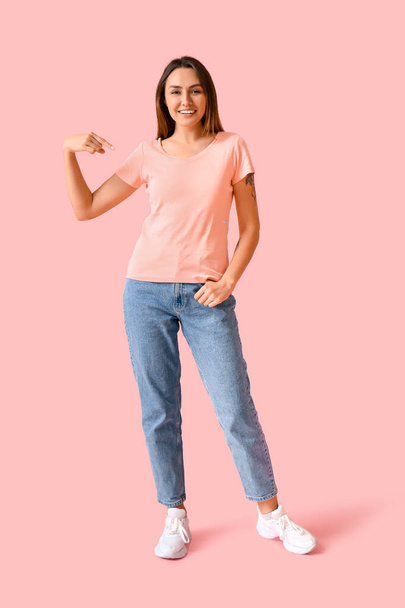 Mujer joven en camiseta en blanco sobre fondo de color - Foto, Imagen