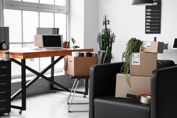 Boîtes en carton avec effets personnels et mobilier à l'intérieur du bureau le jour du déménagement - Photo, image