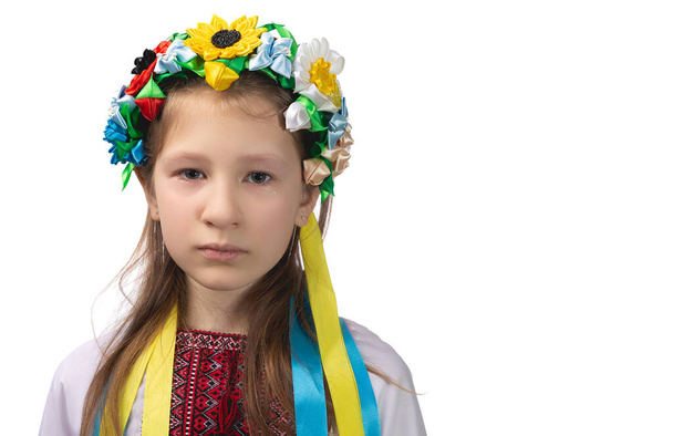 Portret małej ukraińskiej dziewczynki z łzawymi oczami. Dziecko w krajowej sukience. Studio zdjęcie na białym tle. - Zdjęcie, obraz