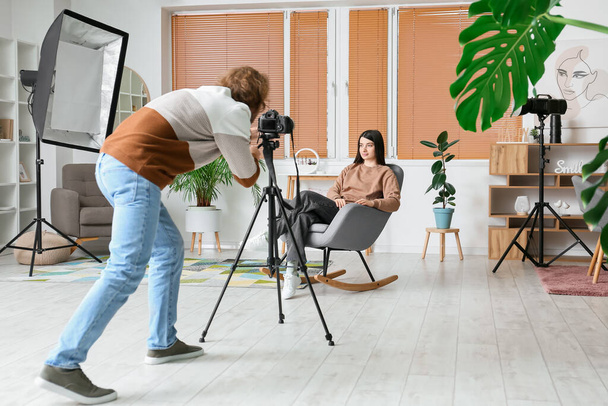 Fotograaf maakt foto van vrouwelijk model in moderne studio - Foto, afbeelding