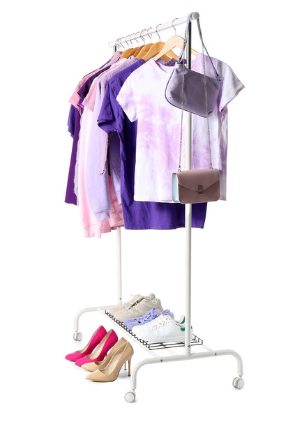 Estante con ropa, zapatos y bolsos femeninos sobre fondo blanco - Foto, Imagen