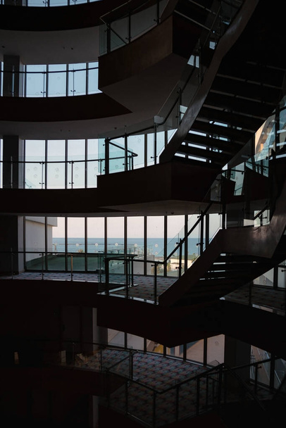 вид из стеклянного высотного здания отеля с широкими лестницами на море, Турция, Алания - Фото, изображение
