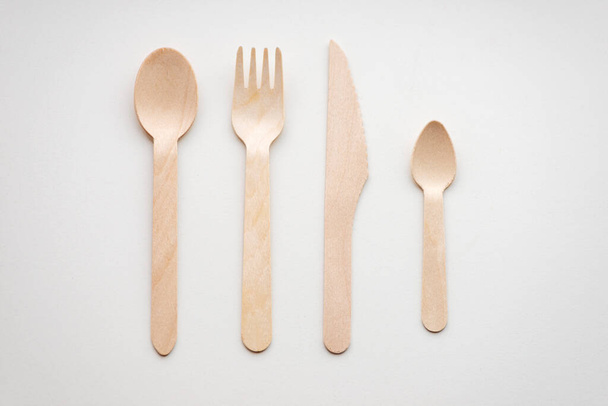 Shot of wooden eco-friendly cutlery lying in a row on a white background. Ecology concept - Valokuva, kuva