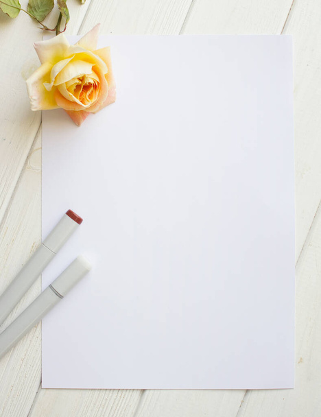 Mockup A4-es papír egy szál rózsával és rajzanyaggal - Fotó, kép