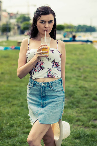 Beautiful girl on the beach drinking orange juice. - Foto, Imagem