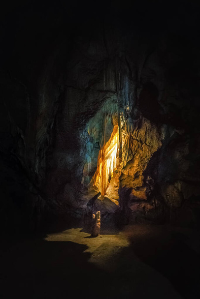 kleurrijke gordijnen in donkere grot verlicht door lichten - Foto, afbeelding